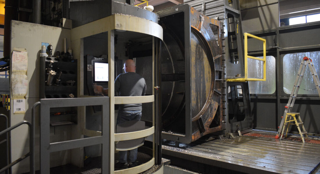 Estructura de horno de grandes dimensiones siendo mecanizada en la fresadora Zayer Kairos 12000. Vista general de técnico en la cabina de control de la frresadora